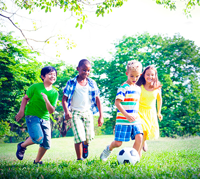 children playing soccer in a grass area