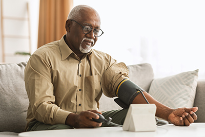 man checking his blood pressure with home pressure reader
