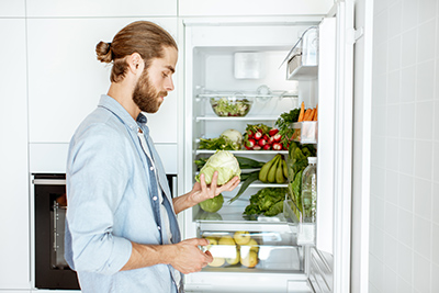 man taking fruits and vegetables out the refrigerator