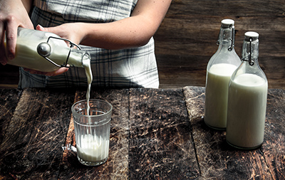 woman pouring milk into a glass