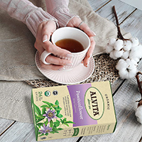 womans using both hands to hold a cup of tea