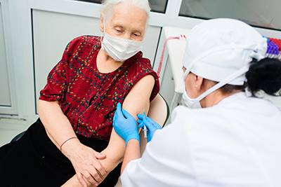 nurse checking blood glucose levels of older adult