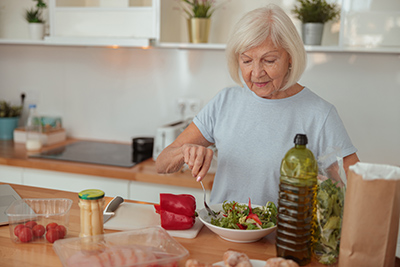 elderly woman preparing healthy meal