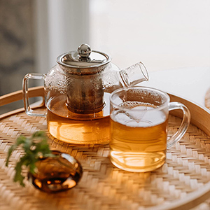table with glass kettle and teacup filled with skullcap tea