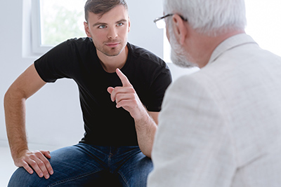 Young man going through psychotherapy session with professional therapists