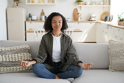 woman meditating on the couch