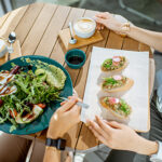 healthy food on a table while a woman waits with a fork to dig in