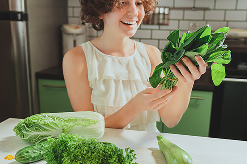 woman with green leafy vegetables for proper nutrition. Nutrition for ideal health.