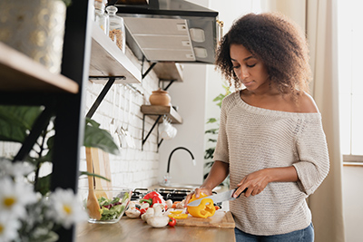 woman cutting a sweet pepper on a cutting board