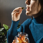 woman taking a herbal gummy vitamin