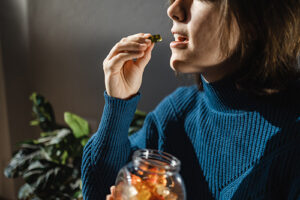 woman taking a herbal gummy vitamin