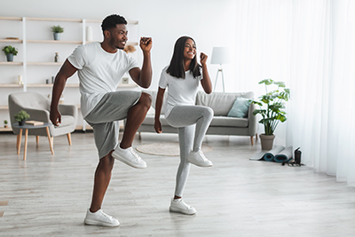 man and woman exercising together inside the home.