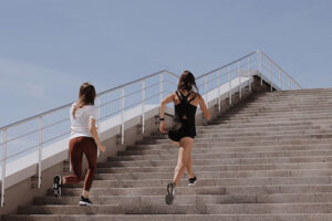 two women running up steps exercising