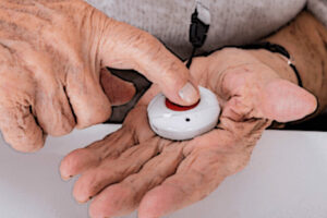 elderly person pressing the button of a medical alert device
