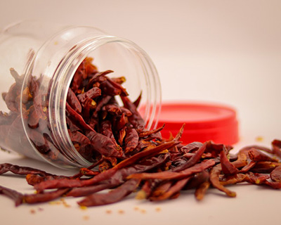 dried cayenne peppers half out of a jar