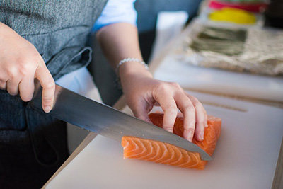 someone slicing into a salmon steak