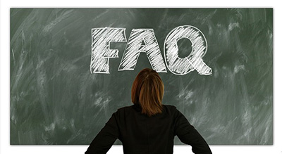 Woman standing in front of a black board with the word FAQ written on it