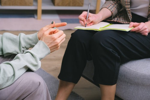 doctor taking notes while talking to patient