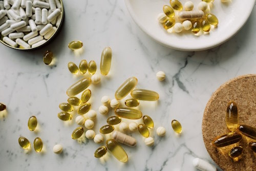 wide array of different types of supplements in containers and on a table