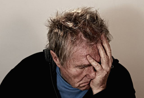 man suffering from extreme migraine