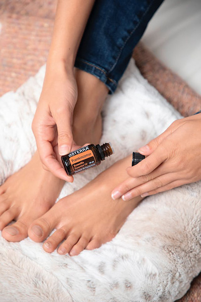 woman putting frankincense on her ailing feet