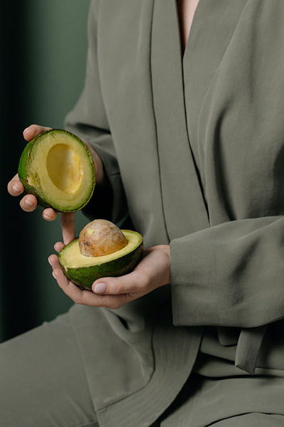 someone holding cut open avocado