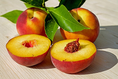 three peaches with one cut in half