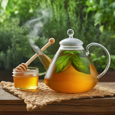cup of basil tea alongside honey