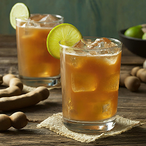 tamarind juice in a glass with ice and lemon slice for garnish