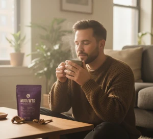 Man sipping a cup of mud/wtr mushroom coffee.