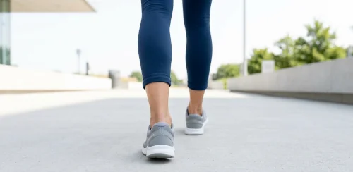 Rear view of a person walking barefoot showing heel and ankle alignment relevant to overpronation and flat feet gait assessment.